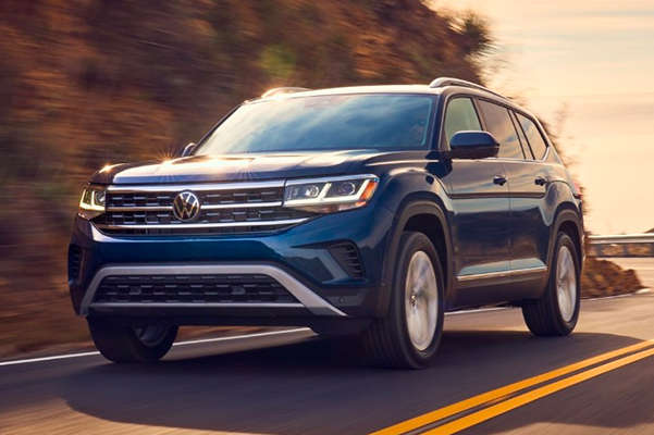 Front shot of the Atlas shown in Tourmaline Blue Metallic driving on the road at sunset.